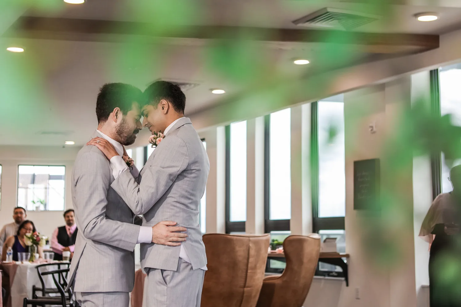 Two grooms sharing a kiss at their wedding.